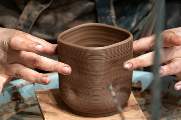 Naklejka na ściany i meble hands while crafting pottery detail close up