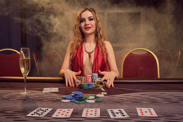 Charming woman with a beautiful hairstyle and perfect make-up is playing poker. Casino.