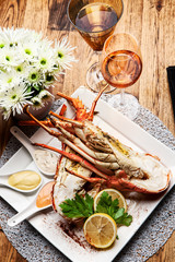 Fabulous lobster dish on wooden table with wine and all the finesse of a luxury restaurant.