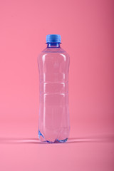 Plastic bottle of still healthy water isolated on pink background