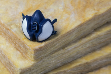 Gas mask sitting on top of some mineral wool rockwool (stonewool) panels (dark version) top