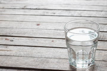 Fresh water in the glass on wooden table.