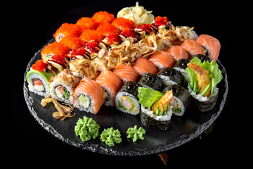 Sushi set with fresh ingredients on black background. Sushi menu. Japanese food. 
