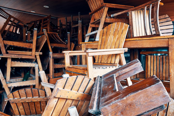 Pile of old obsolete wooden chairs in a storage