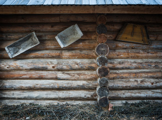 The wall of a wooden house with objects of rustic life.