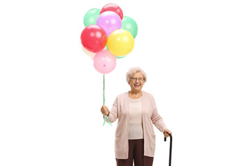 Senior woman holding a bunch of balloons