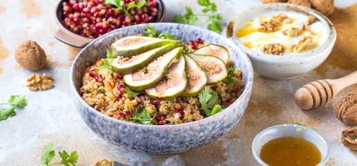 close-up view of tasty healthy couscous salat with figs fruits, nuts and pomegranate seeds 