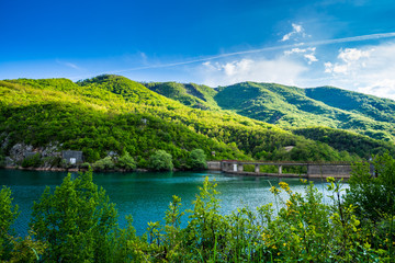 Fototapeta na wymiar Montenegro, Barrier lake water and dam of jezero liverovoci inside green valley surrounded by green trees and forest near niksic city