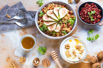 close-up view of tasty healthy couscous salat with figs fruits, nuts and pomegranate seeds 