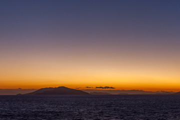 Dreamlike sunset with islands of the Aegean Sea at horizon