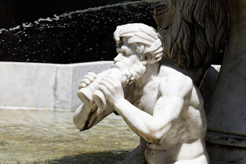 Triton, greek God. Marble sculpture. Fountain in the city park