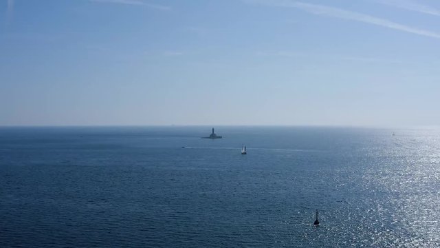 AERIAL flying towards a lighthouse on a tiny island off the coast of Croatia