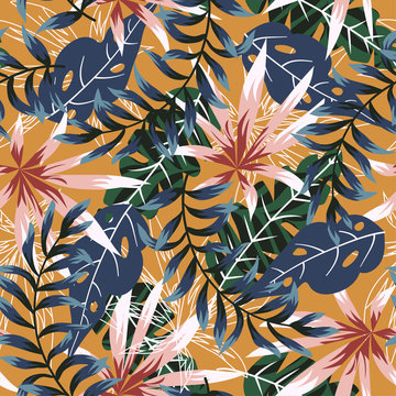 Trend seamless pattern with colorful tropical leaves and plants on orange background. Vector design. Jungle print. Flowers background. Printing and textiles. Exotic tropics. Fresh design.