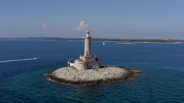 AERIAL slowly circling a lighthouse on a tiny island off the coast of Croatia