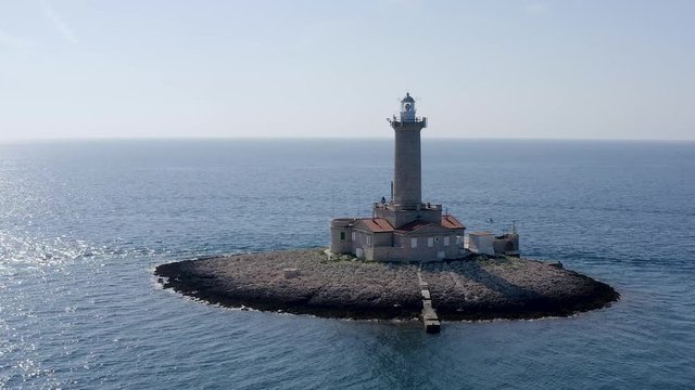 DRONE slowly circling a lighthouse on a tiny island off the coast of Croatia
