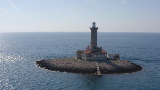 DRONE slowly circling a lighthouse on a tiny island off the coast of Croatia