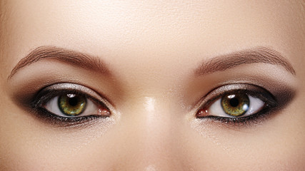 Closeup female eyes with bright make-up, great shapes brows, extreme long eyelashes. Celebrate makeup, luxury eyeshadows