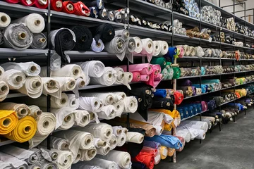 Fototapeten Fabric warehouse with many multicolored textile rolls © Andriy Bezuglov