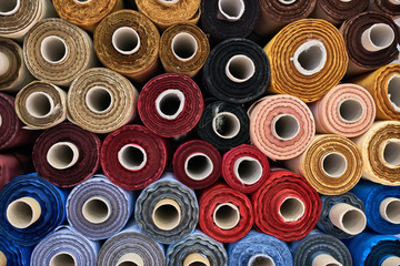 Fabric warehouse with many multicolored textile rolls - 280049420