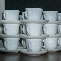 White coffee cups with saucers in stacks