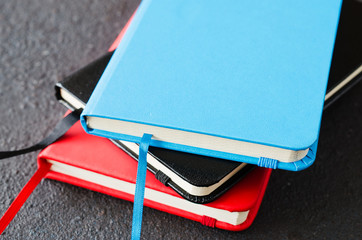 Stack of colorful notebooks for writing or books on dark background