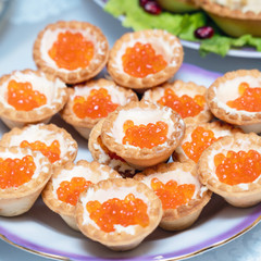 Tartlets with red caviar on a plate. Selective focus