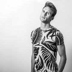 Elegant young handsome man in stylish T-shirt. Black-white photo.