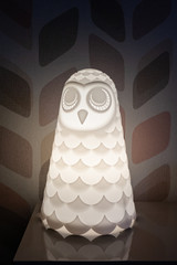 Owl shaped lamp on the bedside of a room.