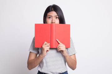 Fototapeta premium Young Asian woman with a book cover her face.