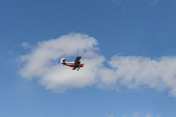 Old biplane flying in the blue sky with cloud