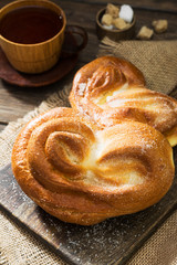 Bun sprinkled with sugar. Sweet pastries. Rustic style