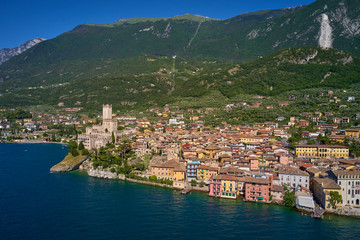 Aerial photography with drone, on the medieval lakeside castle with a museum of history and paleontology, as well as a panoramic view from the tower. City of Malcesine on Lake Garda, Italy.