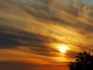Fototapeta na wymiar The sun goes down. Beautiful fan of clouds