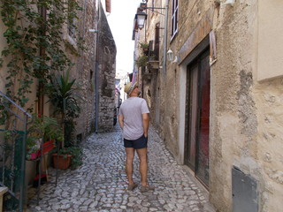 Mężczyzna w kapeluszu spaceruje uliczkami Sermonety, Italia