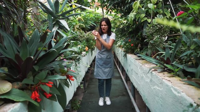 The girl in the greenhouse in the apron, itching from pollen plants. Allergic to flowers
