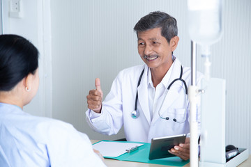 Senior male doctor smile discussing with  speaking with his senior patient