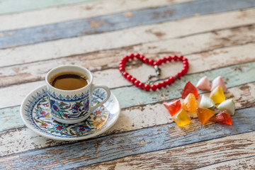 Turkish coffee, sugar candies, and heart shaped rosary on the table