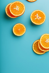 Round slices of juicy orange on a blue background, top view as a background substrate. Food background