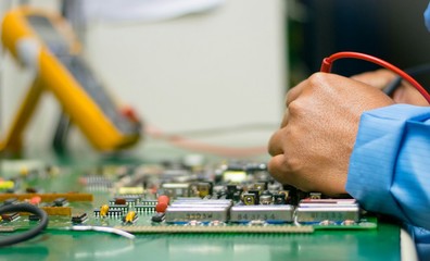 Engineer checking voltage on board electronic for repair.