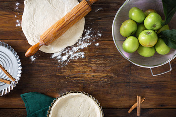 Ingredients for cooking homemade apple pie on old rustic wooden background top view