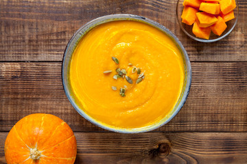 Pumpkin soup on wood background. Vegan food concept
