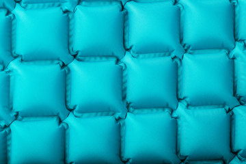 Texture of a blue inflatable tourist rug, repeating sections and patterns. Air mattress Ultralight Portable rug.