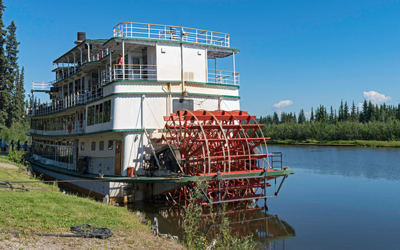 tourists boarding a sternwheel river boat to cruise the Chena River near Fairbanks in Alaska with the river and forest in the background