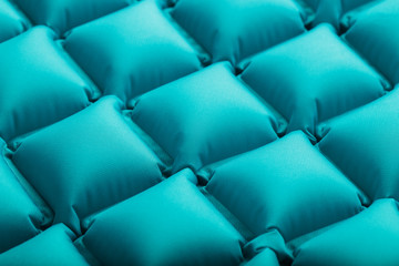 Texture of a blue inflatable tourist rug, repeating sections and patterns. Air mattress Ultralight...