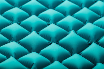 Texture of a blue inflatable tourist rug, repeating sections and patterns. Air mattress Ultralight Portable rug.