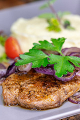 gegrilltes Schweinesteak mit Zwiebeln