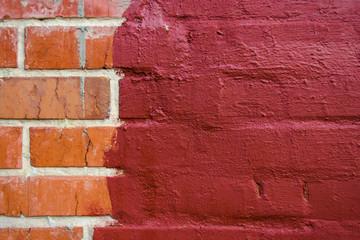 red brickwork half painted in dark red paint