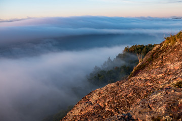Misty clouds rolling over the horizon and cliff