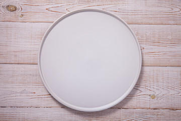 Empty plate on white wooden table. Empty tray mock up for design. Top view.