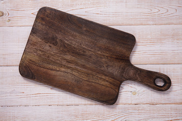 Cutting board on the wooden background. Top view.